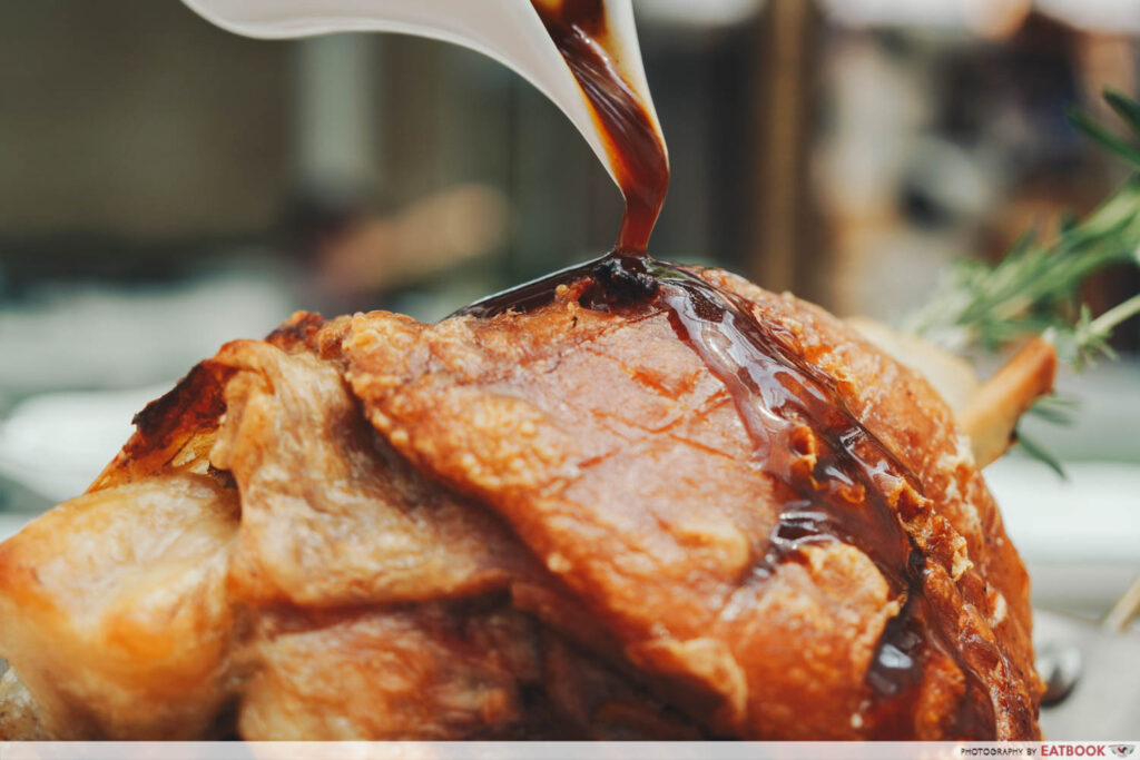 Pouring the sauce on the pork knuckle