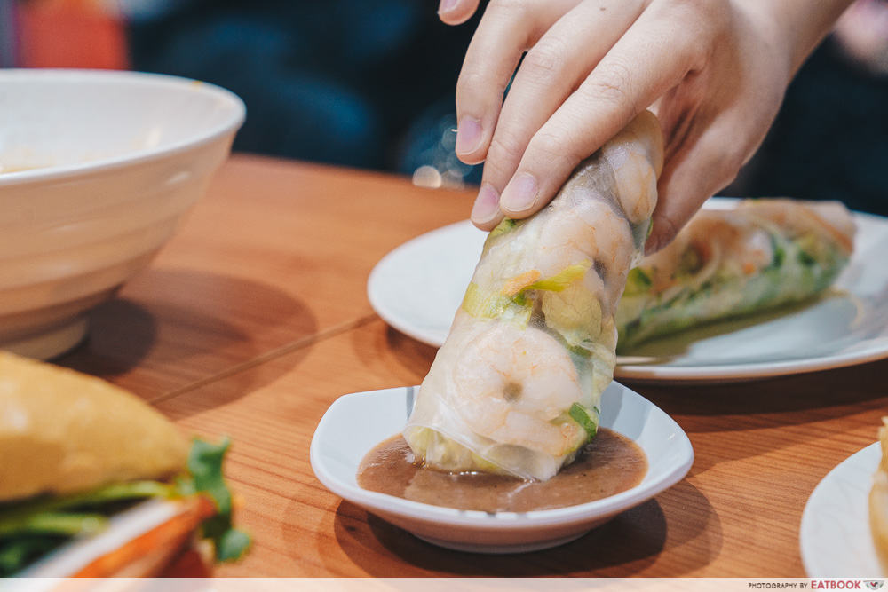 Dipping a fresh spring roll into chilli