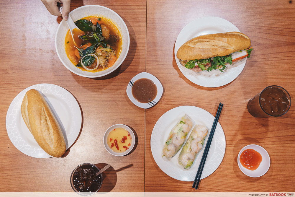 Flatlay comprising banh mi, fresh spring rolls and beef stew