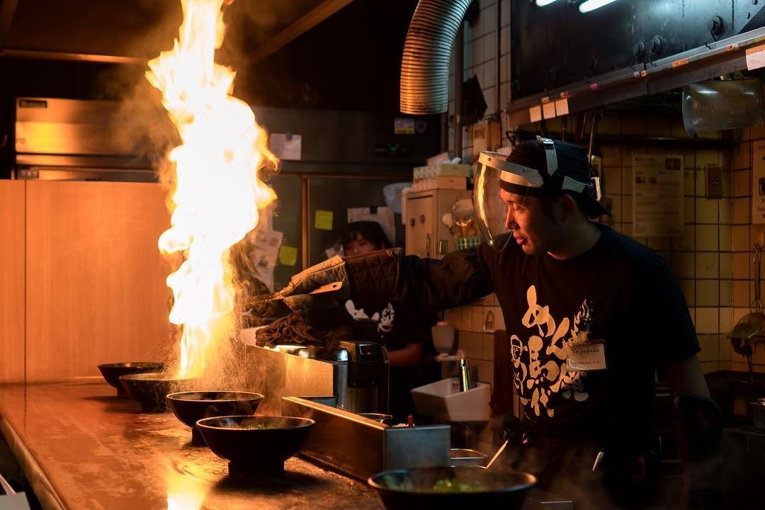 Menbaka Fire Ramen - Chef pouring oil on ramen