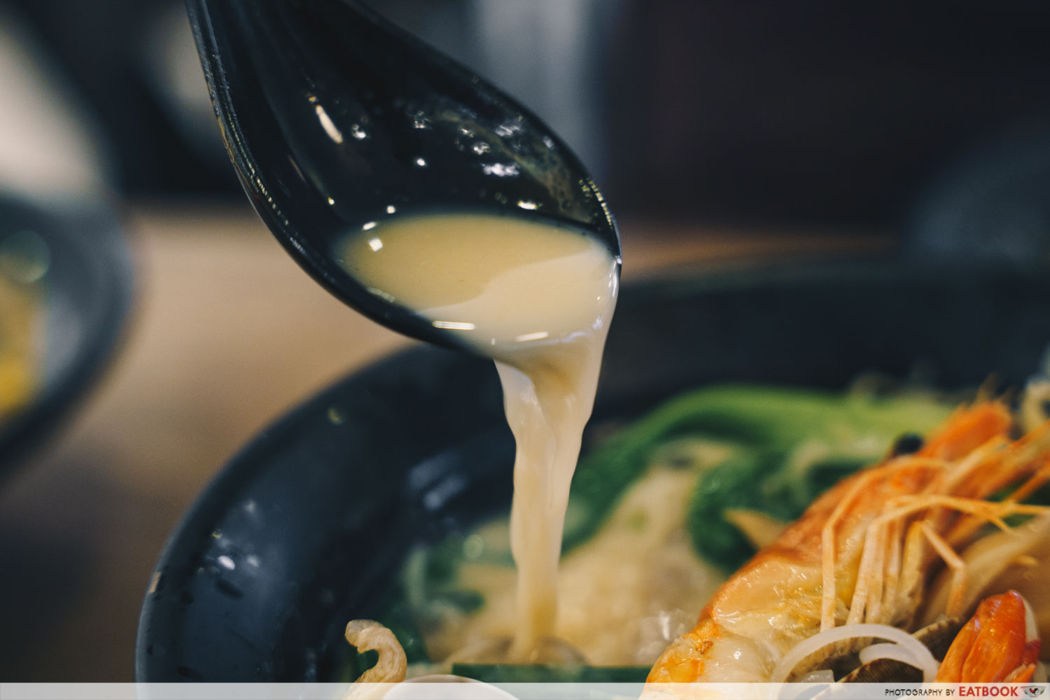 Try Fresh XO Seafood Noodles - Pouring shot of XO broth